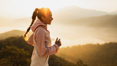 A woman takes a run in the early morning sunlight