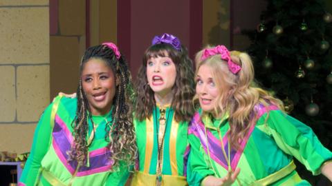The Dribble sisters from CBeebies Christmas Panto Cinderella, wearing lime green track suits for exercise, lean in as they sing.