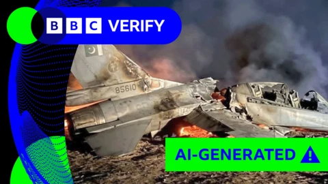 Image of crashed F-16 jet surrounded by flames and smoke with AI-generated green tag on the image 