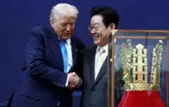 트럼프 미국 대통령과 이재명 한국 대통령이 지난해 경주에서 열린 APEC 행사에서 이 대통령이 선물한 왕관 앞에서 악수하고 있다
