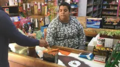 Yanina atendiendo a un cliente en su supermercado