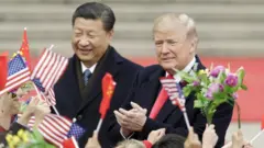 Le président américain Donald Trump, à droite, et Xi Jinping, le président chinois, saluent les participants qui agitent les drapeaux nationaux américain et chinois lors d'une cérémonie de bienvenue à l'extérieur du Grand Hall du Peuple à Pékin, en Chine, le jeudi 9 novembre 2017.