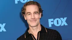James Van Der Beek for red carpet. E dey smile wit blue backdrop behind am 