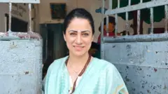 Une femme se trouve à l'extérieur d'une salle de classe dans un quartier marginal de la ville de Bombay.