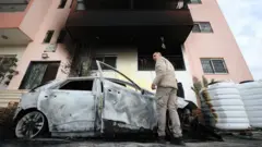 Фаластиннинг оккупация остидаги Ғарбий Соҳилида жойлашган Дайр ал Ҳатоб қишлоғи яшовчиси яҳудий келгиндиларнинг ўт қўйганидан кейин автомобилини текшираяпти