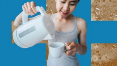 Mulher jovem, de roupa cinza, despeja água quente de uma chaleira em uma caneca