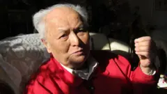 Ông Lý Nhuệ trong bức ảnh chụp trước khi qua đời, mặc áo khoác đỏ và áo sơ mi cổ trắng.