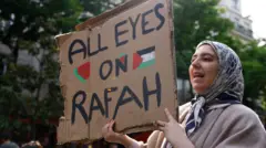 Un manifestant pro-palestinien tient une pancarte sur laquelle on peut lire « Tous les yeux sur Rafah » alors que des manifestants se rassemblent devant l'université de la Sorbonne, où ils ont tenté d'installer un camp de protestation avant d'être évacués par la police, à Paris, France, le 29 avril 2024.