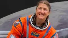 Christina Koch con su traje de astronauta color naranja