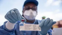 Une infirmière au service de l'OMS montre un flacon contenant un vaccin Ebola, à Mbandaka, en RDC.