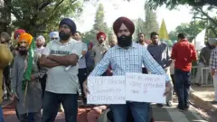 पंजाब विश्वविद्यालय, चंडीगढ़ के केंद्रीकरण के विरोध में प्लेकार्ड लेकर खड़ा एक सिख व्यक्ति. तस्वीर में कई अन्य लोग भी नज़र आ रहे हैं