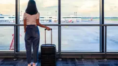 విమానాశ్రయంలో ఎదురుచూస్తున్న మహిళ