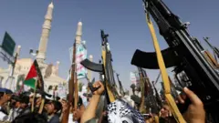 መሳሪያ ከፍ አድርገው የያዙ እጆች