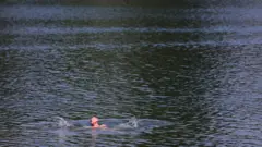 Čovek se kupa na jezeru Ada Ciganlija u Beogradu