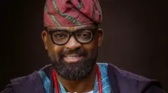 Kunle Afolayan wọ agbada aṣọ oke, o si de fila pẹlu ilẹkẹ lọrun
