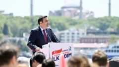 İnan Güney arkasında Ayasofya silüetinin bulunduğu bir yerde, açık hava konuşması yapıyor.