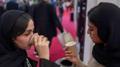 بازدیدکنندگان ایرانی در تاریخ ۱ دسامبر ۲۰۲۴ از نمایشگاه قهوه ایران در مجتمع تجاری ایران مال در شمال غرب تهران بازدید می کنند.