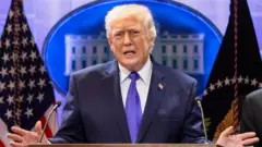 US President Donald Trump gestures as he speaks during a press briefing at the White House