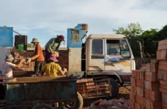 Trabalhadores em caminhão com tijolos