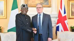 Ààrẹ Nàìjíríà, Bola Tinubu àti olóòtú ìjọba UK, Sir Keir Starmer dúró, wọ́n ń ba ara wọn lọ́wọ́
