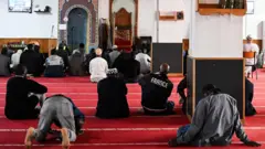 Məsciddə insanlar ibadət edirlər.