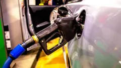 carro sendo abastecido com combustível