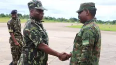 Umugaba w'ingabo za Mozambique Major General André Rafael Mahunguane (iburyo) aramukanya na Brig Gen Cooper Mike Mujuni uri mu bakuriye ingabo z'u Rwanda ubu muri Mozambique