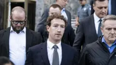 Zuckerber resmi giyimli yanında birkaç adamla birlikte merdivenlerden iniyor gibi görünüyor. 