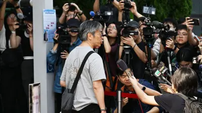 一名宏福苑居民到位於中環展城館聽證會現場,接受在場多間傳媒訪問。