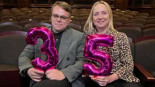 Pasha e a jornalista Katie Razzall, da BBC, seguram balões que formam 35