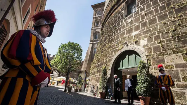 Siège de l'IOR avec des gardes suisses gardant la porte.