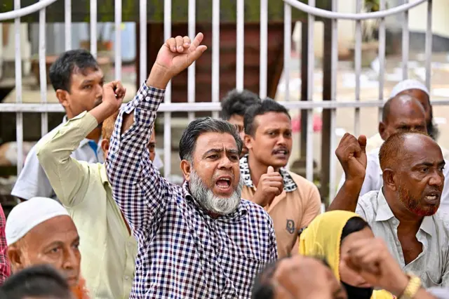 একদল লোক হাত উঁচু করে স্লোগান দিচ্ছে