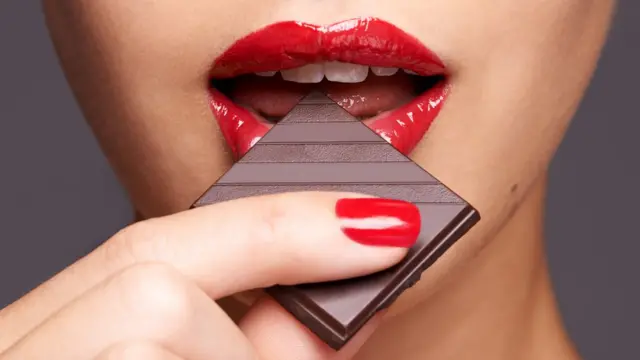 A woman's lips biting a piece of chocolate චොකලට් ලිංගික ක්රියාකාරකම්