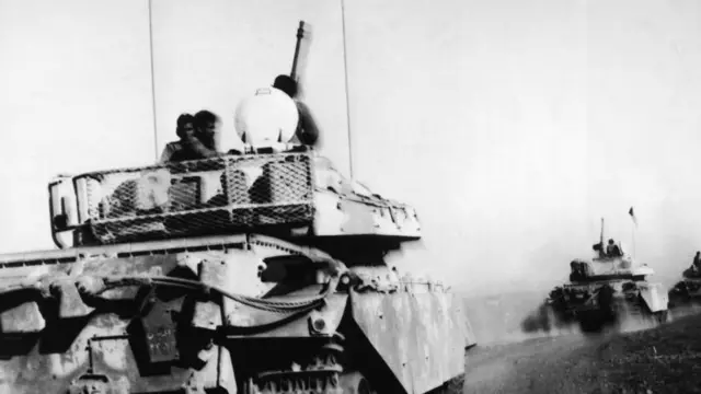 Une photographie en noir et blanc légèrement floue montrant des chars Centurion jordaniens de fabrication britannique arrivant sur le plateau du Golan pour soutenir les Syriens pendant la guerre du Kippour.