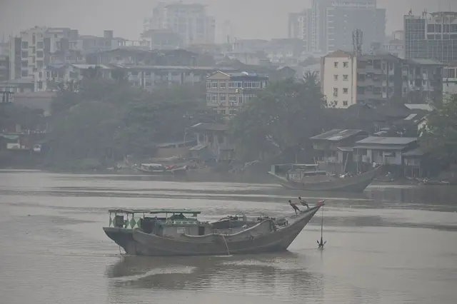 ရန်ကုန်မြစ်အတွင်းက စက်လှေတစ်စင်းနဲ့ မှုံဝါးနေတဲ့ ပတ်ဝန်းကျင်မြင်ကွင်း