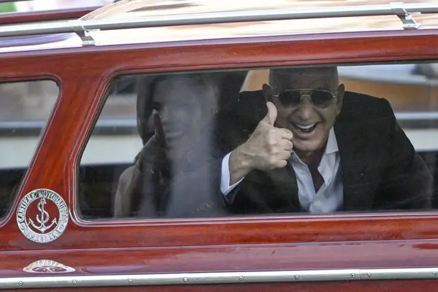 Санче и Безос показывают одобрительный большой палец из водного такси.