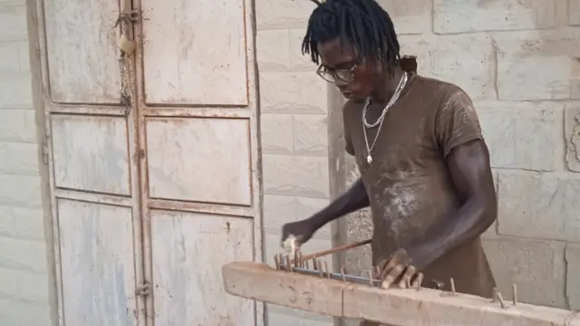 Le ferrailleur Alioune Thiam à l'oeuvre devant un bâtiment en chantier à Santa Yalla à Rufisque