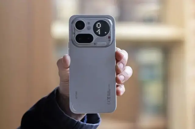 دستی یک گوشی موبایل را رو به دوربین گرفته است