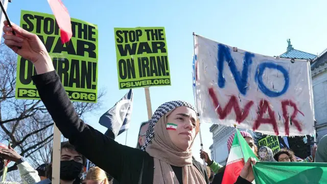 ሕጃብ ዝገበረት፡ ኣብ ምዕጕርታ ባንዴራ ኢራን ዝተቐብአት ጓለንስተይቲ ትርአ። ብዙሓት ሰባት ኣብ ዋሽንግተን ባንዴራ ኢራን እናንበልበሉ ነቲ ኲናት ተቓውሞኦም ይገልጹ።