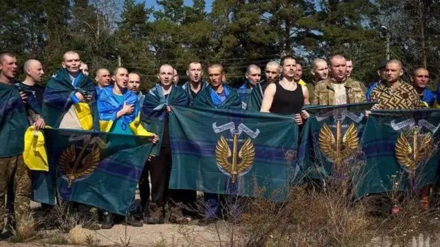 تفنگداران دریایی اوکراینی آزاد شده که با پرچم ژست گرفتهاند