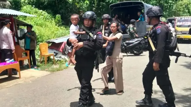Personel kepolisian dari Satbrimobda Polda Malut evakuasi warga Sibenpopo usai bentrok di Halteng, Selasa (07/04).