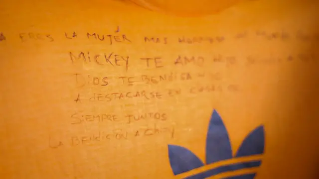 Một thông điệp viết bằng mực đen trên chiếc áo phông màu cam sáng