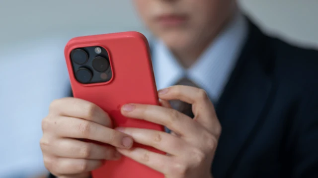 telefonuna bakan bir çocuk