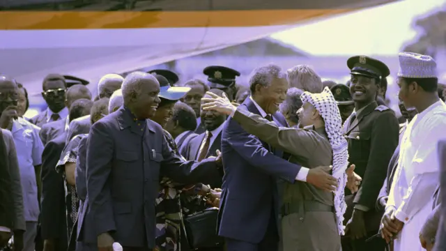 PLO Chairman Yasser Arafat hug South African President Nelson Mandela, on 01 January 1990 while odas smile dey look