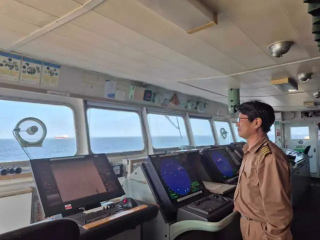 정박된 배 안 조정 레이더 앞에 최 선장이 창 밖으로 바다를 바라보고 있다. 