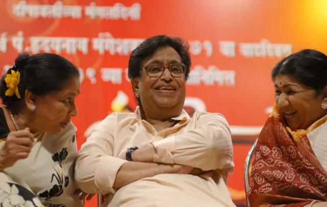 साल 2008 में आशा भोसले (बाएं) और लता मंगेशकर, हृदयनाथ मंगेशकर (बीच में) के 72वें जन्मदिन के मौके पर मुंबई में हुए एक कार्यक्रम में
