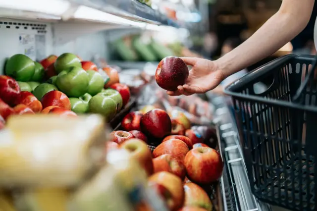etando una manzana en un supermercado.