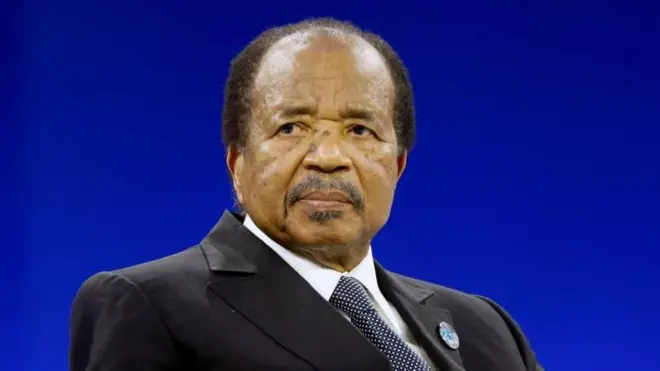 Paul Biya, vêtu d'un costume, est vu assis