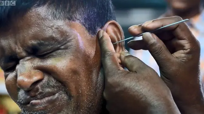 ช่างกำลังแคะขี้หูลูกค้า