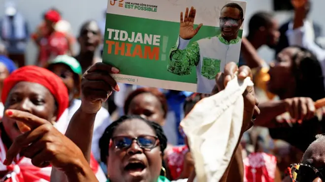 Des sympathisantes du PDCI protestent contre une décision de justice visant à retirer leur leader Tidjane Thiam de la liste électorale à Abidjan, en Côte d'Ivoire. L'une d'entre elles brandit une affiche de campagne de Thiam - 24 avril 2025
